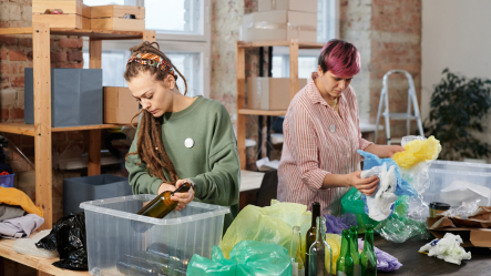 Deux femmes travaillant activement dans un atelier à organiser des matériaux recyclés, illustrant l'engagement de Cycléaa pour une protection menstruelle durable.